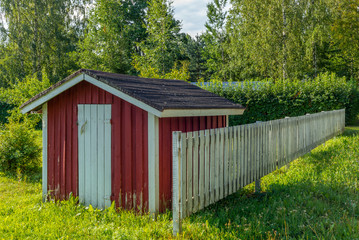 A typical red garden house in a farm in Finland