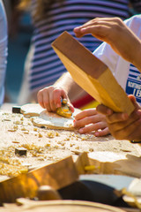 Children learn to make custom violin and other musical instruments in outdoor fablab classes. Joiner's training on makerfaire.