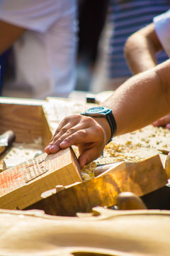 Children learn to make custom violin and other musical instruments in outdoor fablab classes. Joiner's training on makerfaire.