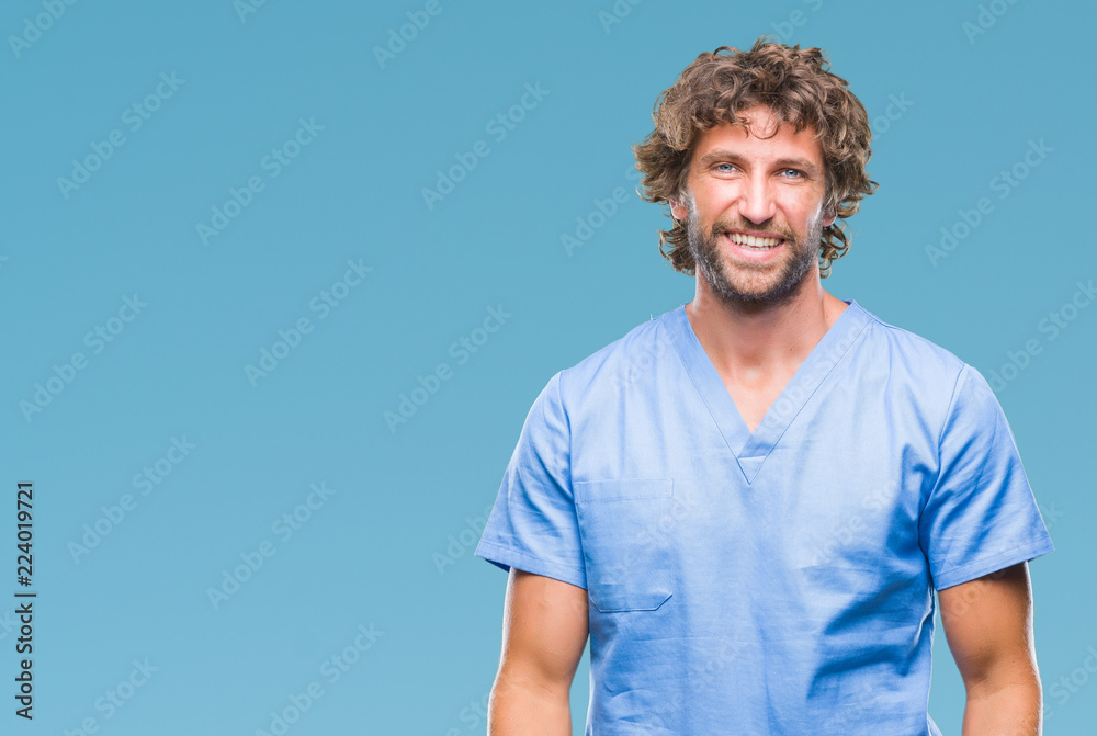 Wall mural Handsome hispanic surgeon doctor man over isolated background with a happy and cool smile on face. Lucky person.