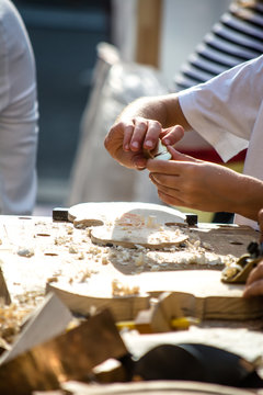 Children learn to make custom violin and other musical instruments in outdoor fablab classes. Joiner's training on makerfaire.