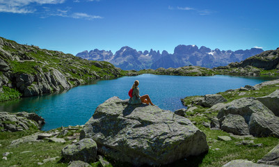 Woman sitting on a rock in Italian mountains