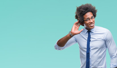 Afro american business man wearing glasses over isolated background smiling with hand over ear...