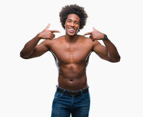Fototapeta premium Afro american shirtless man showing nude body over isolated background smiling confident showing and pointing with fingers teeth and mouth. Health concept.