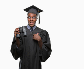 Young graduated african american man looking for a job using binoculars with surprise face pointing finger to himself