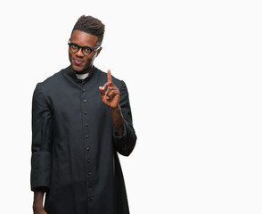 Young african american priest man over isolated background showing and pointing up with finger...
