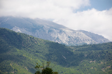 Majestic landscape of the mountains and forest in Caucasus at summer. Dramatic sky with clouds.