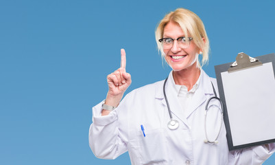 Middle age blonde doctor woman holding clipboard over isolated background surprised with an idea or question pointing finger with happy face, number one