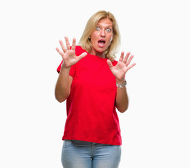 Fototapeta na wymiar Middle age blonde woman over isolated background afraid and terrified with fear expression stop gesture with hands, shouting in shock. Panic concept.