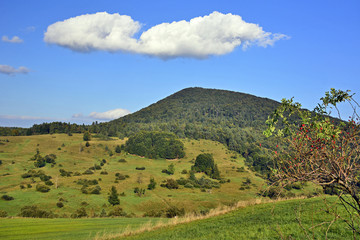Fototapeta na wymiar Mountain with green meadow and blue sky in autumn landscape, Low Beskids (Beskid Niski), Poland