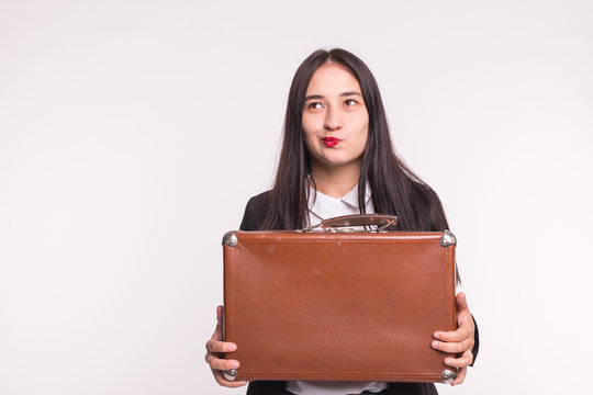 Business, emotions and people concept - young brunette girl keep a suitcase and thinking about a question on white background with copy space