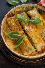 Close-up of cannelloni baked with spinach and cheese, high angle view, vertical shot