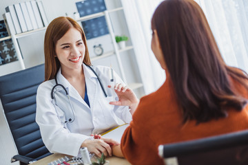 Asian doctor woman holding syringe injection needle with young asian patient woman, asian medical concept