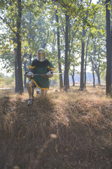 Medieval Knight holding a sword in the forest on his knees