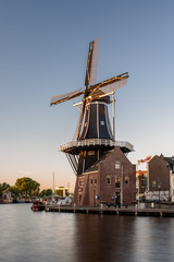 Fototapeta na wymiar Dutch windmill, in the town of Haarlem, at sunset. 