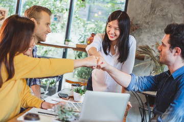 Business diversity people stacking hands for teamwork concept at cafe