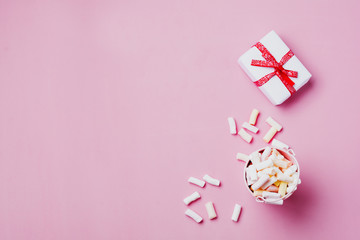 Marshmallows on pink background with copyspace. Flat lay. Background or texture of colorful mini marshmallows.