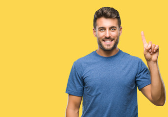 Young handsome man over isolated background showing and pointing up with finger number one while...