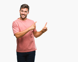 Young handsome man over isolated background smiling and looking at the camera pointing with two hands and fingers to the side.