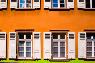 Colorful orange building with white shutters