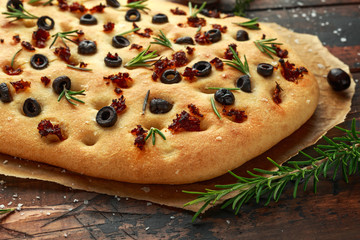 Homemade Italian focaccia with sun dried tomatoes, black olives and rosemary