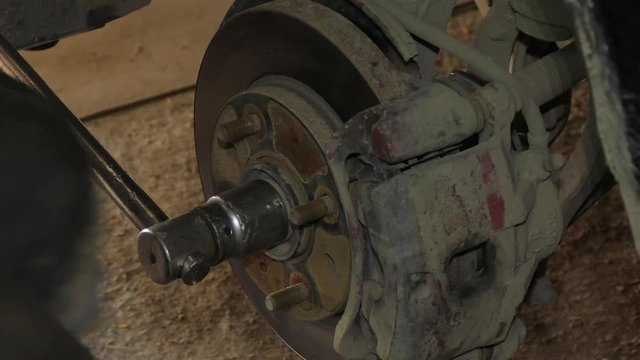 Using a wrench to disassemble the wheel brake disc