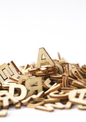 A letter on top of a pile of wooden letters. Isolated on white. Copy scape.