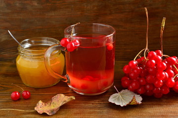 Red hot tea with viburnum berries in a glass cup