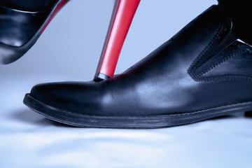 Women's shoes on men's shoe as symbol of conflict, gender inequality and female domination.