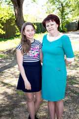 A young, beautiful woman is hugging a teenage girl.  Mom and daughter.