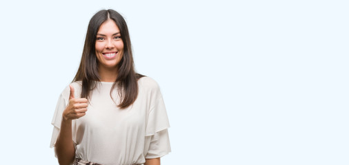 Obraz premium Young beautiful hispanic woman happy with big smile doing ok sign, thumb up with fingers, excellent sign