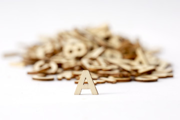 Small wooden letters isolated on white. Copy space. A letter in front.