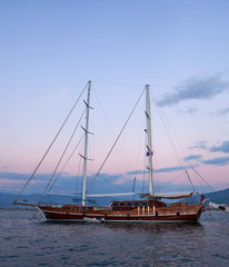 Fototapeta na wymiar Beautiful wooden clipper yacht over sea at sunset