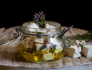 griechischer Feta in Olivenöl eingelegt und mit Rosmarin und roten Paprika gewürzt