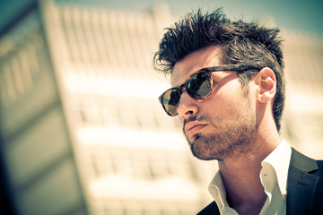 Handsome businessman with sunglasses, outdoor in the city. Charming and modern style, with shirt...