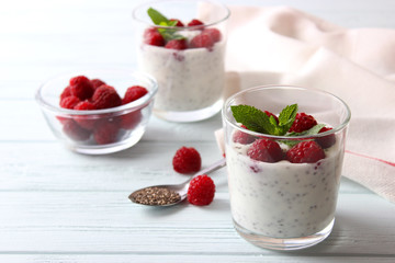 chia pudding in a glass with raspberries on a light wooden table. Proper nutrition, super food