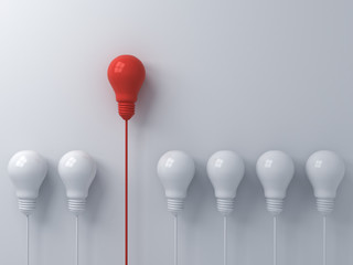 Think different concept One red light bulb standing out from the dim white light bulbs on white wall background with shadows leadership and individuality creative idea concepts 3D rendering