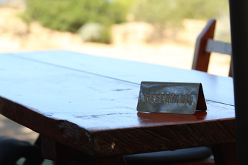 Restaurant table in mediterranean paradise in Ibiza with RESERVADO sign (reserved in spanish language)
