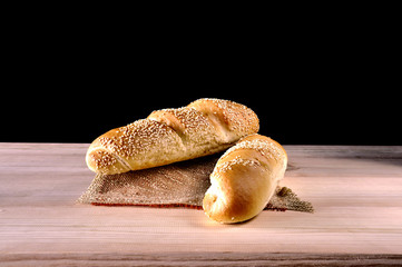 White bread on a wooden table. On a black background.