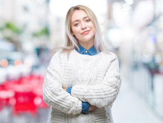 Young blonde woman wearing winter sweater over isolated background happy face smiling with crossed arms looking at the camera. Positive person.