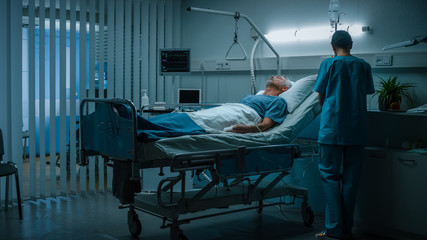 In the Hospital Senior Patient Rests on the Bed, Nurse in Ward Does Checkup. Recovering Man...