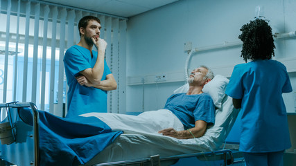 Modern Medical Ward with Sick Patient Lying in Bed and Doctor Thinking About His Treatment. Nurse Does Checkup. Technology Helps Cure Patients.