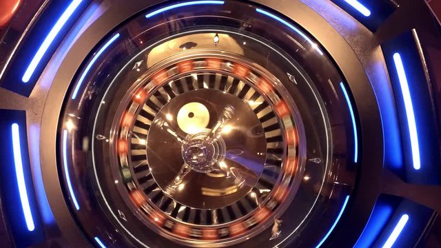 Aerial view of Roulette Wheel spinning under glass sphere with reflections of the overhead lights