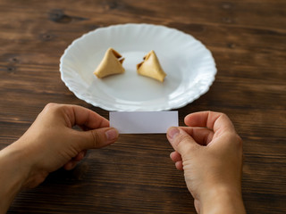 Frau hält den Zettel aus einem Glückskeks in der Hand