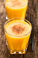 Frischer hausgemachter Kürbis Smoothie oder Milkshake mit Zimt bestreut (Selektiver Fokus, Fokus ein Drittel in die Oberfläche des Getränks)