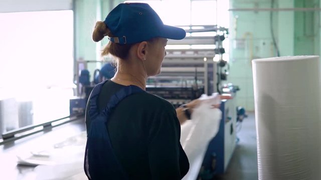 worker in the production of plastic packaging cut into finished products