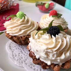 A cake basket with cream and berries and mint leaves.