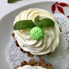 A cake basket with cream and berries and mint leaves.