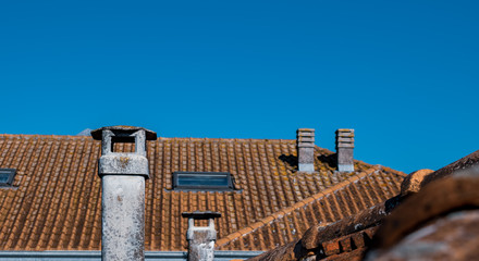 chimneys and roofs on blue sky