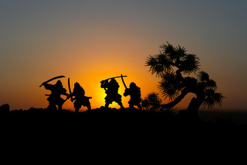 Fototapeta na wymiar Silhouette of two samurais in duel. Picture with two samurais and sunset sky.